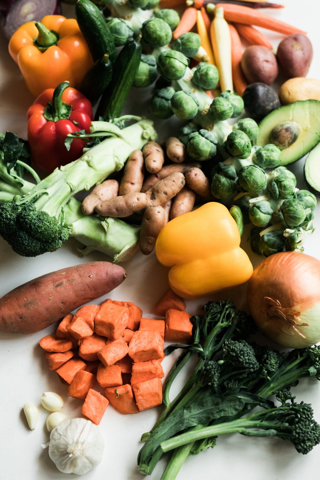 vegetables on table peppers onions carrots broccoli sweet potato